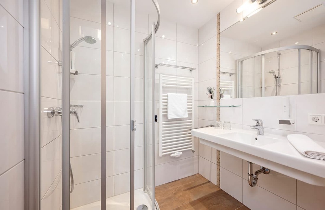 Modernes Badezimmer mit Dusche, Waschbecken und Handtuchheizung