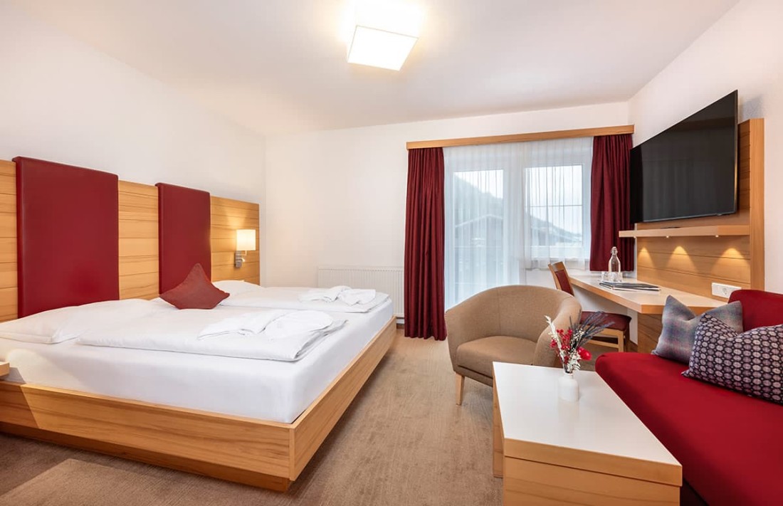 Helles Doppelzimmer mit Doppelbett, Sofa, Sessel, TV und Blick nach drau&szlig;en