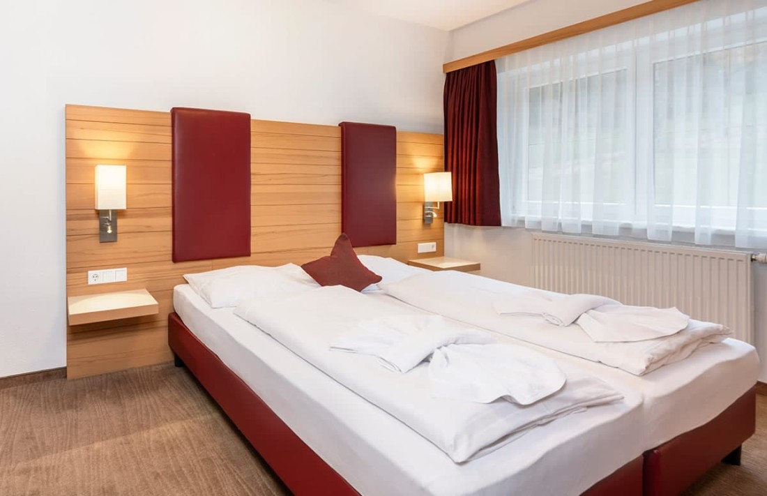 Ein gem&uuml;tliches Familienzimmer mit einem Doppelbett und Nachttischen neben Leselampen