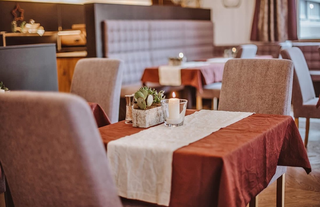 Ein elegantes Restaurant-Interieur mit gedeckten Tischen und brennenden Kerzen