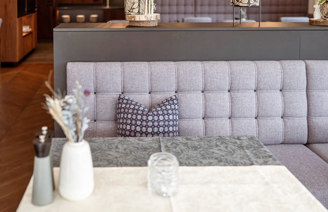 Ein lila gepolsterte Sitzbank mit Kissen und Dekoration auf dem Tisch davor