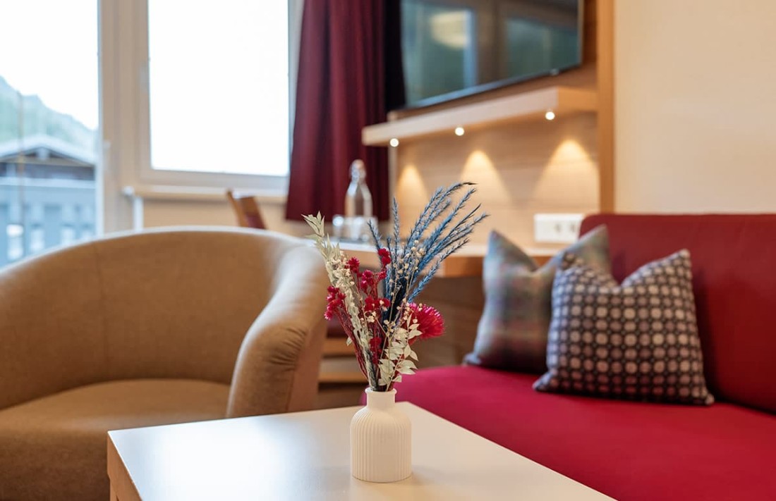 Vase mit Blumenstrau&szlig; steht auf einem Tisch in einem gem&uuml;tlichen Wohnzimmer